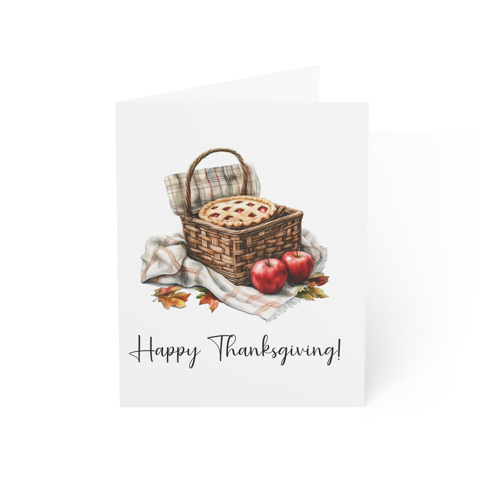 Thanksgiving card with a picnic basket, pie, and apples on a white background