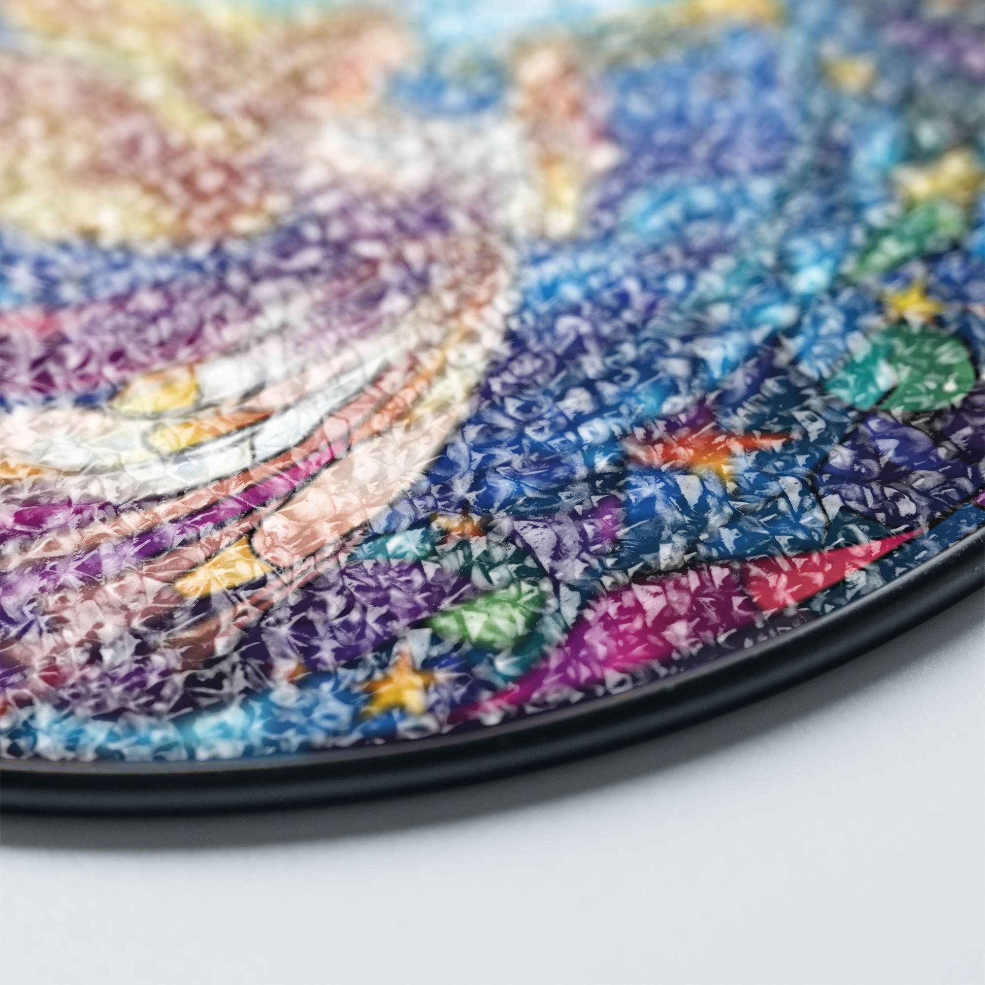 Close-up of a colorful stained glass suncatcher with angel with a gradient of blue, purple, and pink.