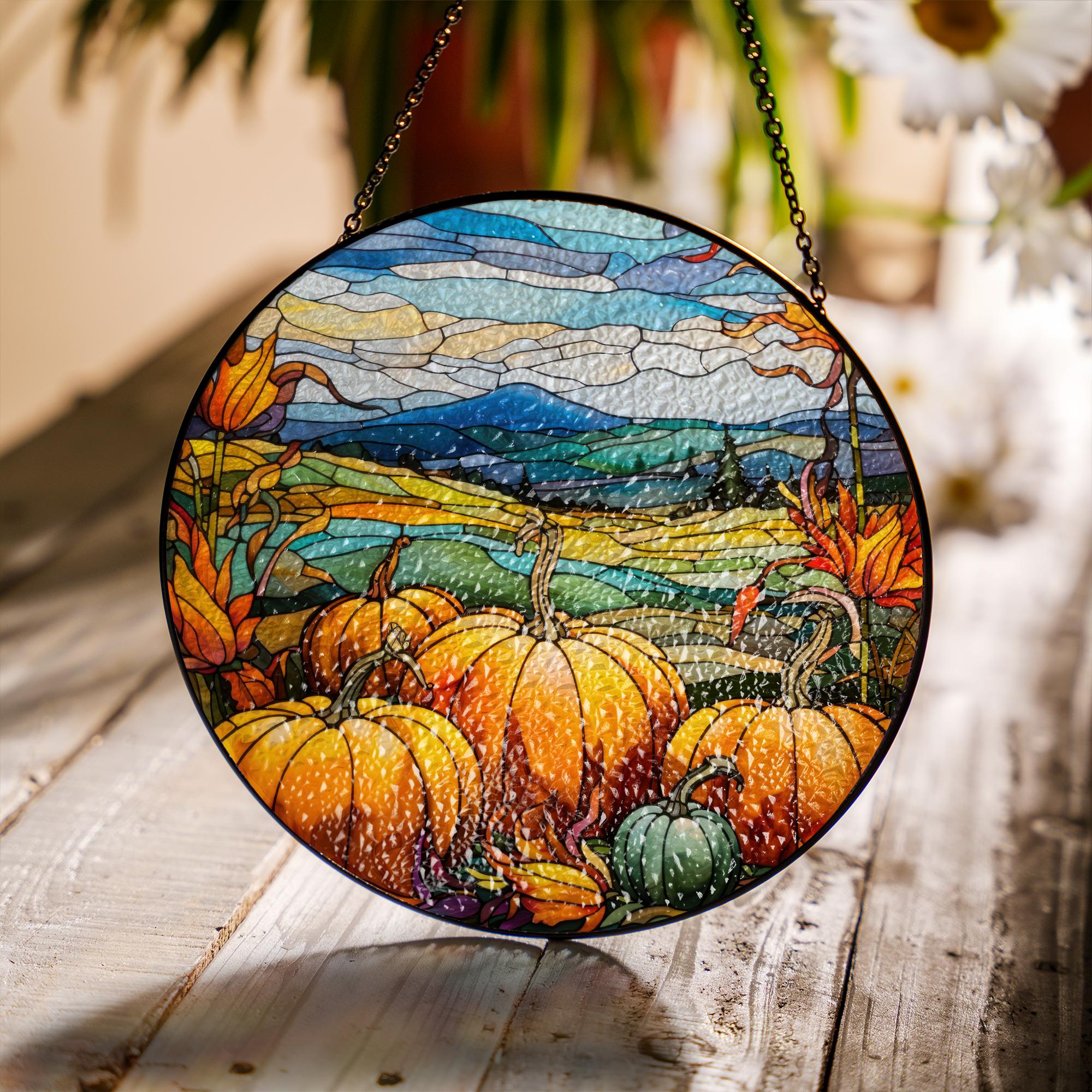 Round stained glass panel with autumn scene featuring pumpkins and leaves on a wooden surface.