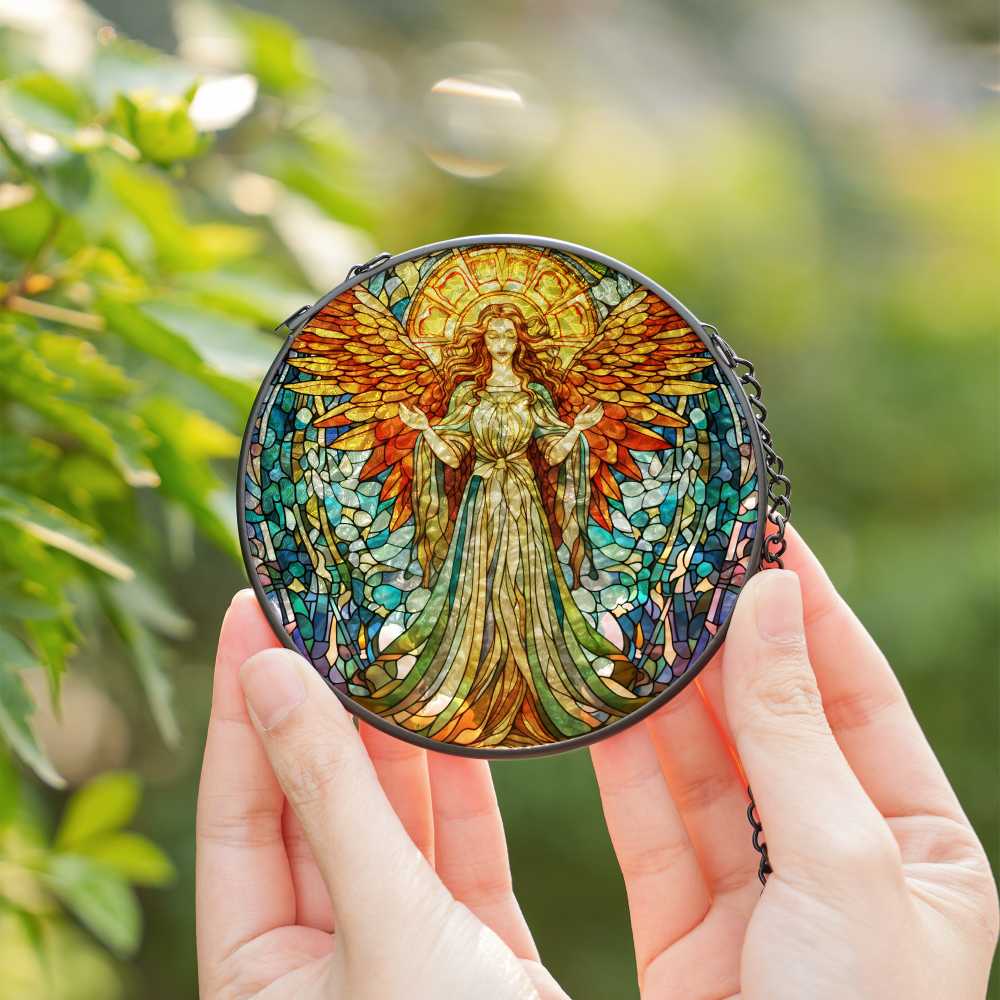 Stained glass angel artwork held by a person with a blurred green background