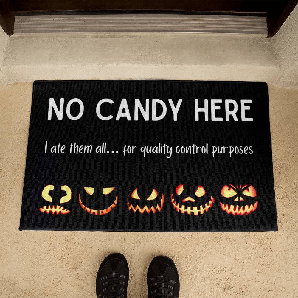 Halloween doormat with pumpkins and text 'No Candy Here' on a carpeted floor.