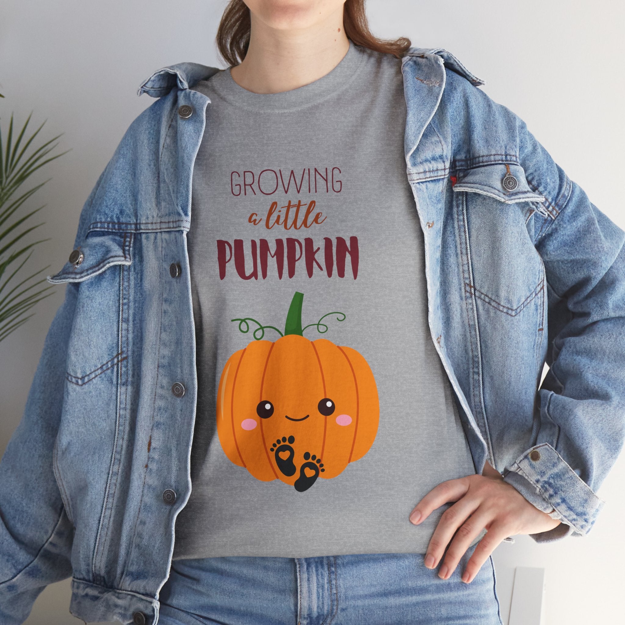 Person wearing a gray t-shirt with a pumpkin graphic and text, paired with a denim jacket.