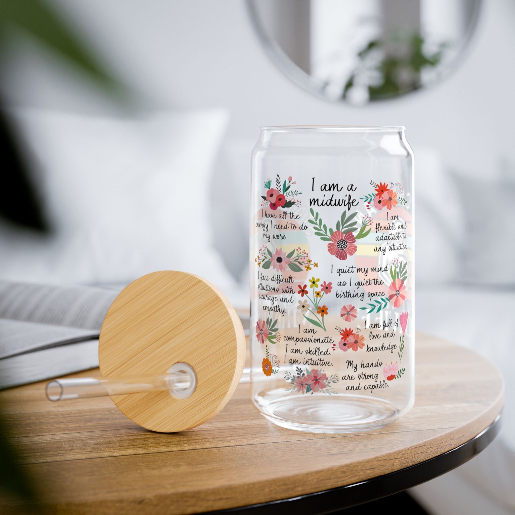 Glass tumbler with floral design and text  for a midwife on a wooden table