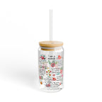 Clear tumbler with floral design and text, wooden lid, and straw on a white background