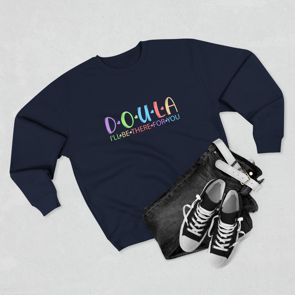 Navy blue sweatshirt with colorful text DOULA I'll be there for you, black clutch, and black sneakers on a light gray background