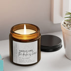 Birth Candle in a glass jar with a label, books, and a potted plant on a surface.