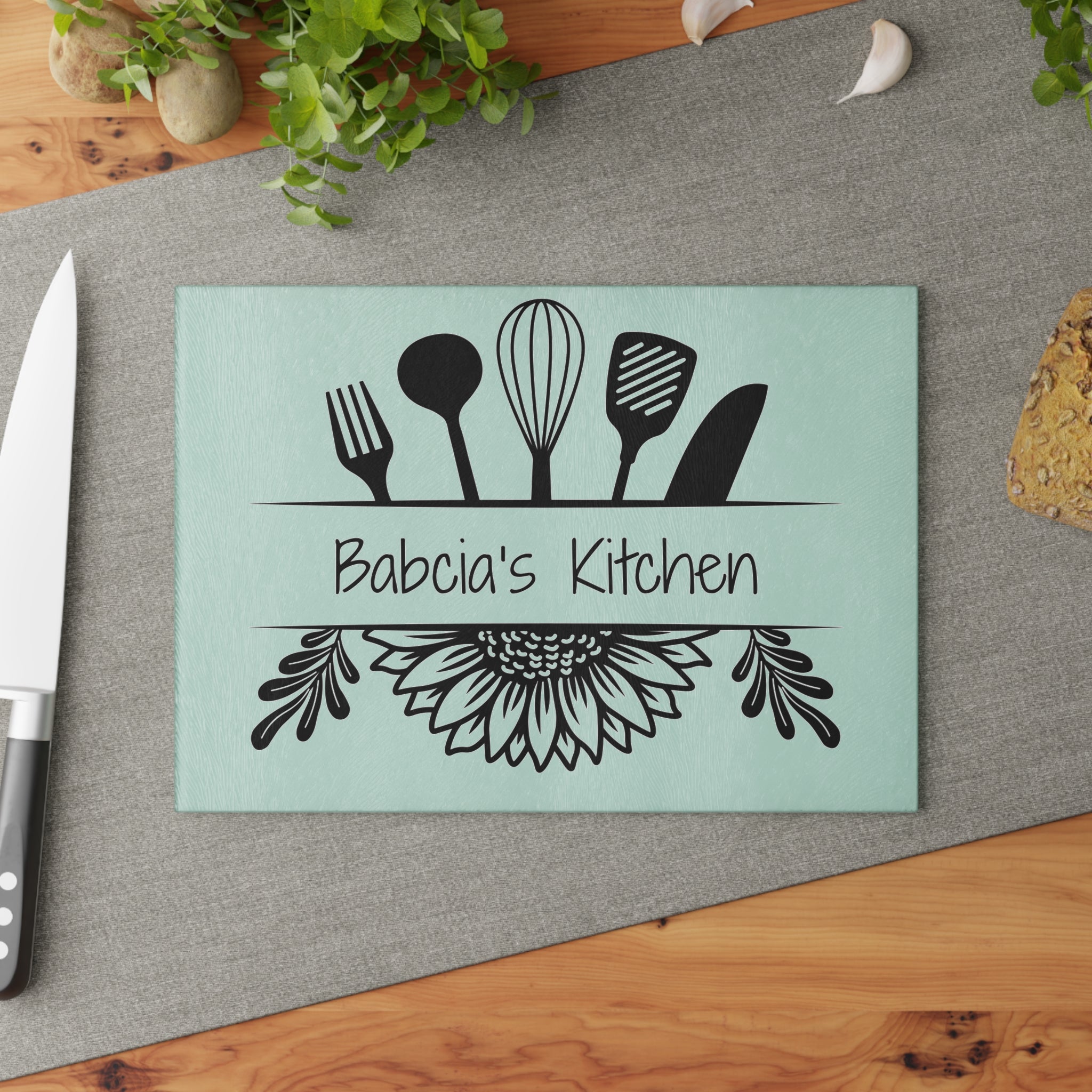 Decorative glass cutting board with utensil design and 'Babcia's Kitchen' text. For Polish babcia in the USA.