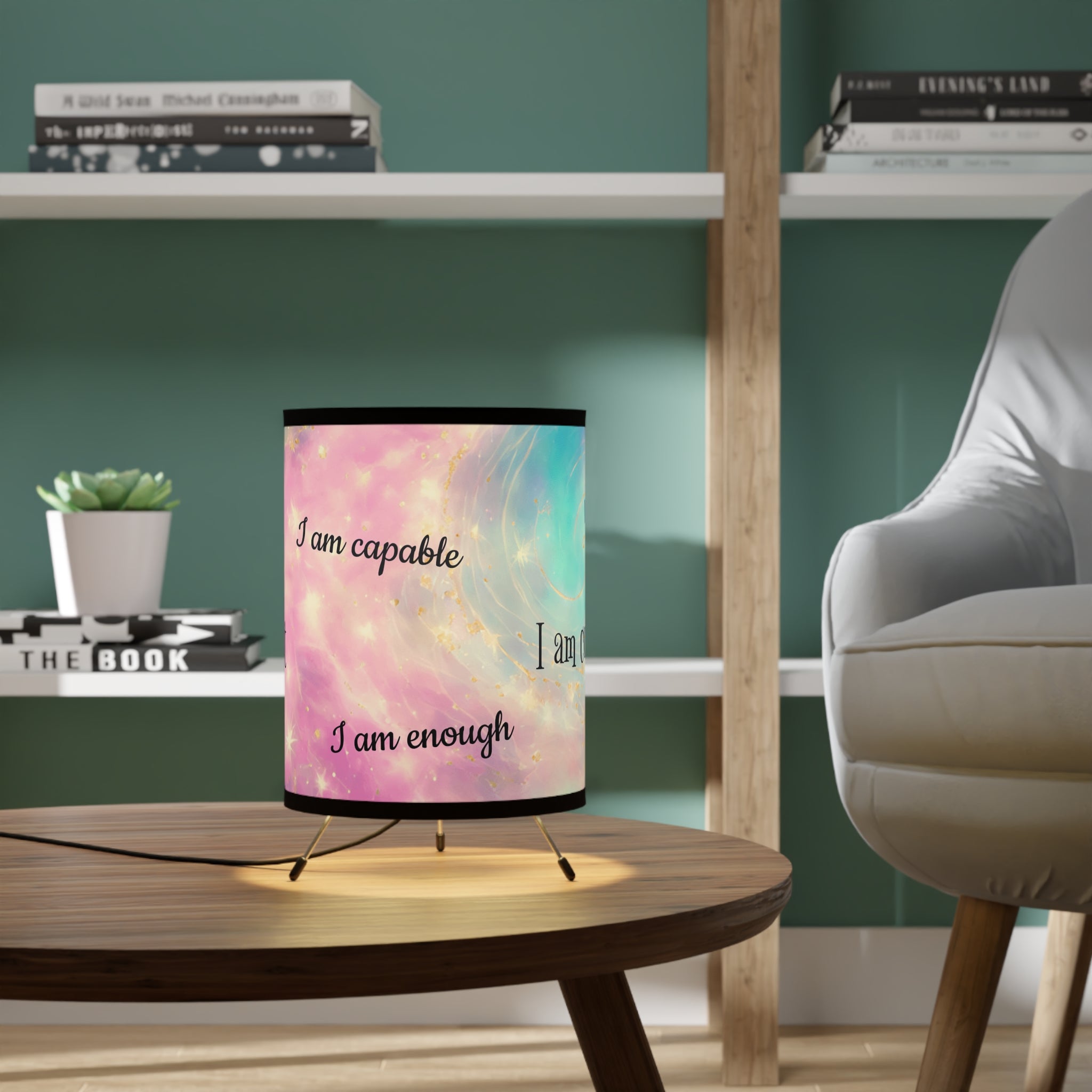 Lamp with motivational quote on a table in a room with books and a plant.
