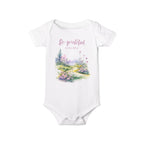 Baby onesie with "So grateful to be alive!" text and pastel nature design, made from soft 100% Airlume cotton, shown flat with envelope neckline and snap closures.