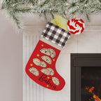 Red Christmas stocking with pierogi cartoon designs and 'Babcia' personalization, hanging by a fireplace.