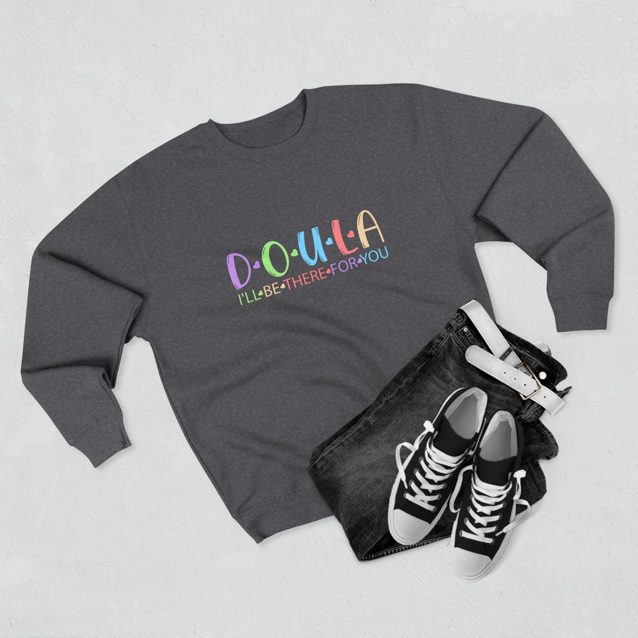 Gray sweatshirt with colorful text DOULA I'll be there for you, black jeans, and black sneakers on a light gray background
