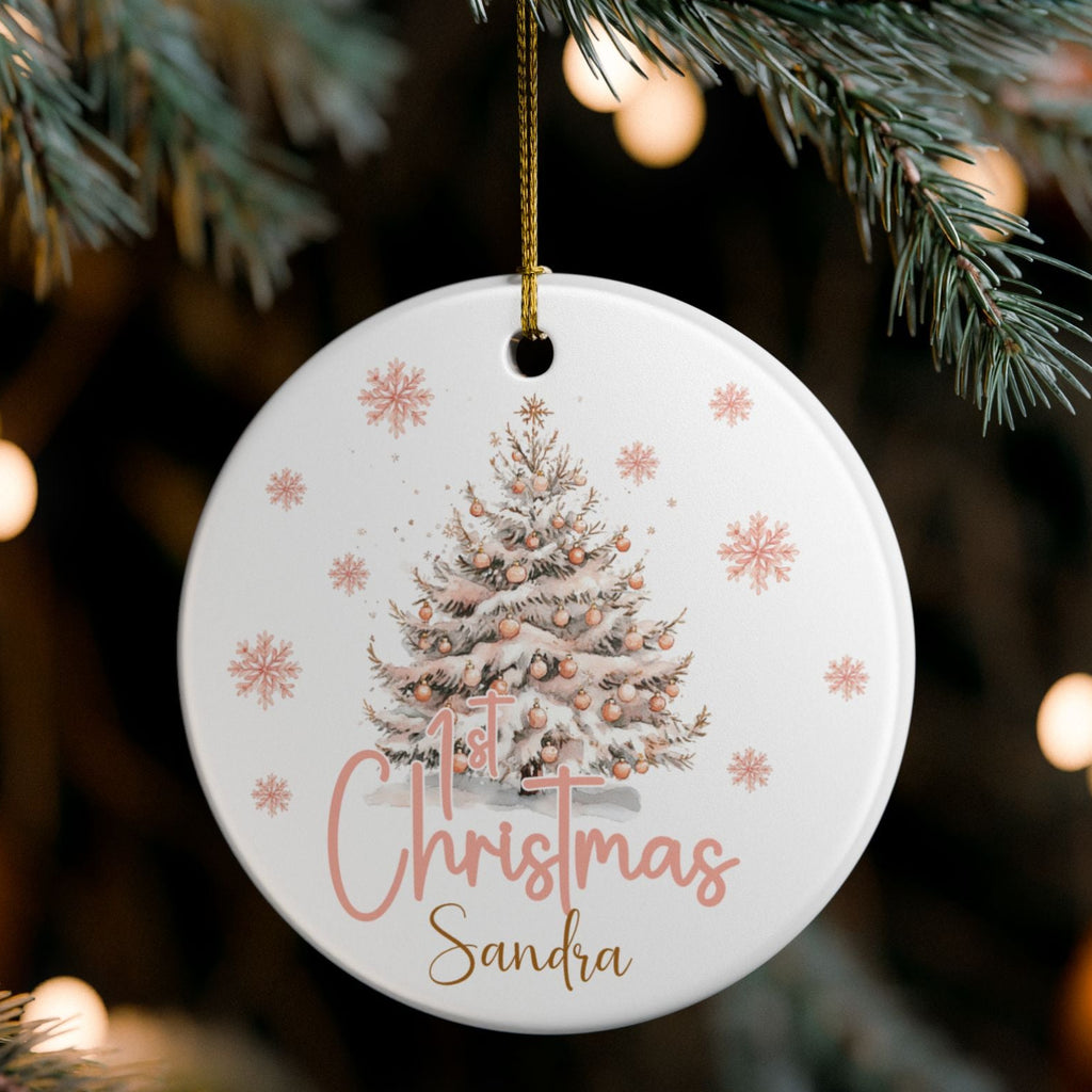 Round Christmas ornament with tree design and 'Christmas Sandra' text, hanging on a tree branch.