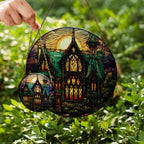 Stained glass suncatcher featuring a gothic mansion with a full moon, hanging in a window and glowing in natural sunlight two sizes