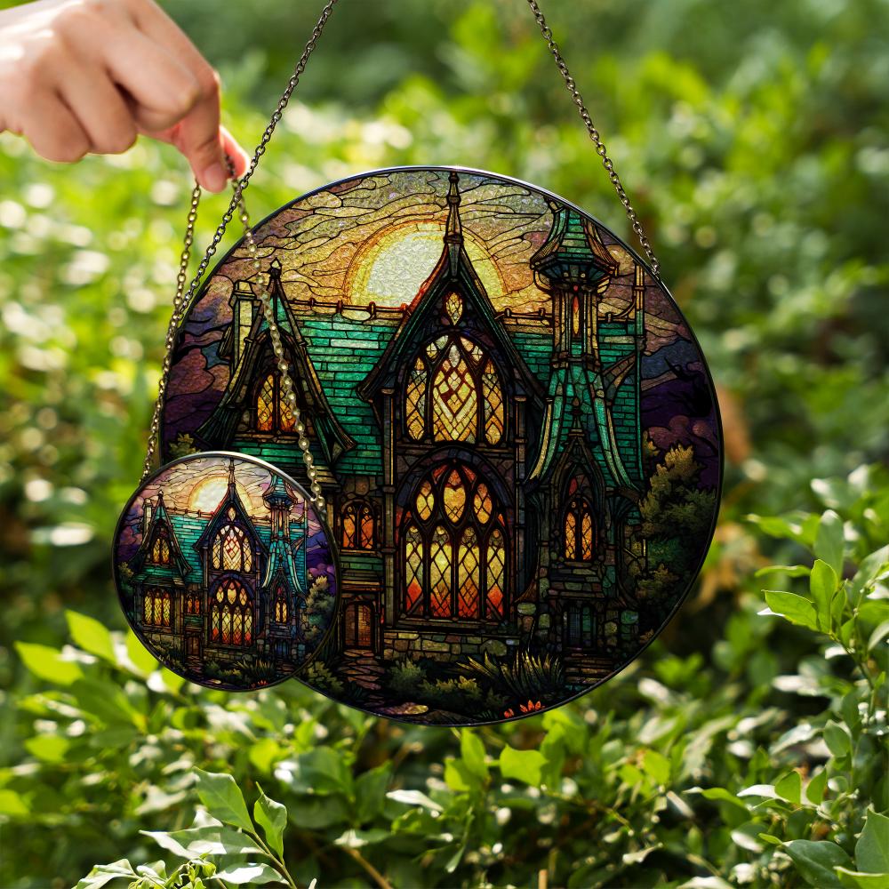 Stained glass suncatcher featuring a gothic mansion with a full moon, hanging in a window and glowing in natural sunlight two sizes