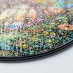 Close-up of a textured, multicolored suncatcher surface with a white background