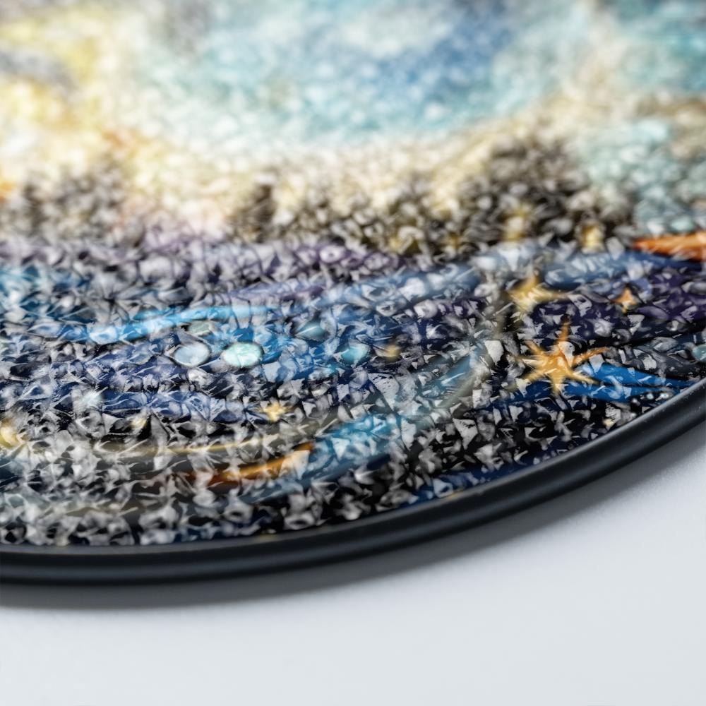 Close-up of a textured surface of a stained glass suncatcher with a gradient of colors on a white background