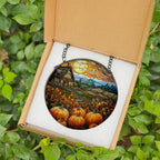 Decorative stained glass piece of a pumpkin patch scene in a box with green leaves in the background