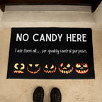 Halloween doormat with pumpkins and text 'No Candy Here' on a carpeted floor.